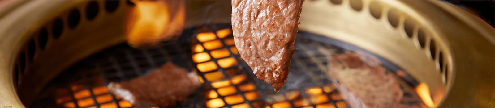 Wagyu beef cooking over the grill at Satsuma no Kubo